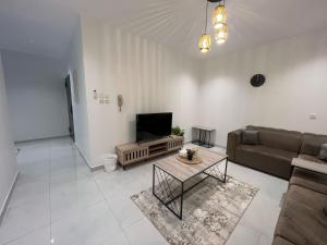 艾卜哈شقق روضة المطار的客厅里有一张沙发和一台电视 更多3张照片