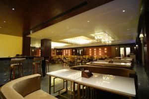 a restaurant with tables and chairs and a bar at Majestic Square in Jammu