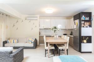 a living room with a table and a kitchen at Villa Alto - 4bdrms, Near Elephant and Mako beach bar in Pefkohori +53 photos