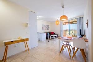 a kitchen and living room with a table and chairs at Arenita 4G in Palm-Mar +13 photos