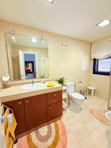 une salle de bain avec un lavabo, des toilettes et un miroir dans l'établissement Cozy Corner Close to Beach, Golf and Shopping, à San Bartolomé