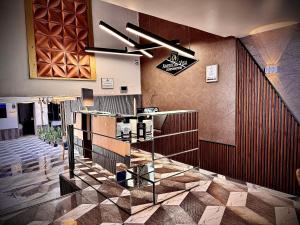 a lobby with a staircase and a sign on the wall at Hotel American Visa Normandia in Bogotá