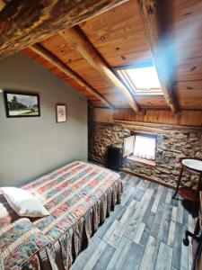 a bedroom with a bed and a stone wall at Casa Pradillo in Añavieja