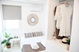 a white dressing room with a white shirt hanging on a closet at Heart of the City Studios in Mikonos