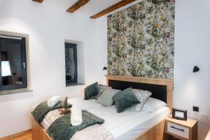 a bedroom with a bed with a large floral wall at Apartmaji Vouk - sodobni apartmaji v objemu narave - Lukanja - Rogla - Primerno za pare in družine - Sprostitev in aktivno preživljanje prostega časa in Oplotnica