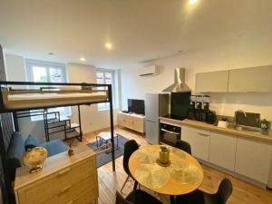 a living room with a table and a kitchen at L'espace d'un instant in Villeneuve-sur-Lot