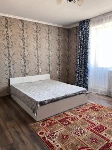 1 dormitorio con 1 cama en una habitación con alfombra en Гостевой Дом, en Kooperator 14 fotos más