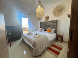 a bedroom with a large bed with towels on it at Apartment haut standing in Ghazoua