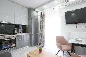 a kitchen with white cabinets and a table and chairs at #Ioanna Apartments Unique in Thessaloniki