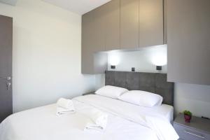 a bedroom with a white bed with two white towels at #Ioanna Apartments Unique in Thessaloniki