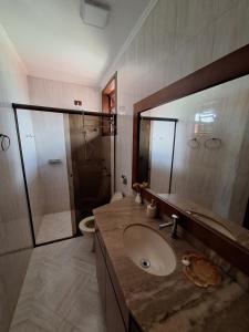 a bathroom with a sink and a shower with a mirror at Amanhecer dos Sonhos in São Francisco do Sul +71 photos