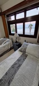 a bedroom with two beds and a large window at Amanhecer dos Sonhos in São Francisco do Sul