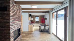 a living room with a fireplace and a brick wall at Przystanek Jaworki - Apartament w Jaworkach in Szczawnica
