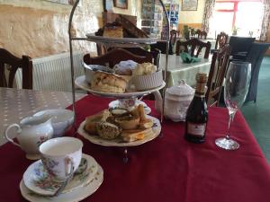 a table with a plate of pastries and a bottle of wine at Pot A Doodle Do in Berwick-Upon-Tweed