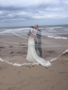 a bride and groom standing on the beach at Pot A Doodle Do in Berwick-Upon-Tweed +5 photos