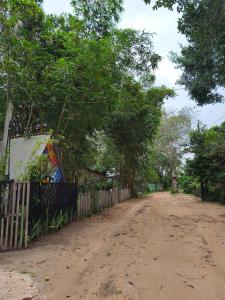 a dirt road next to a fence and trees at Luz de Maria in Belém