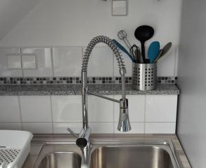 a kitchen sink with a faucet in a kitchen at Appartements Sieben-Seen Mölln in Mölln +8 photos