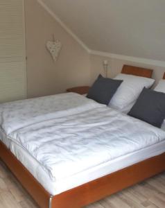 a bedroom with two beds with white sheets and blue pillows at Appartements Sieben-Seen Mölln in Mölln