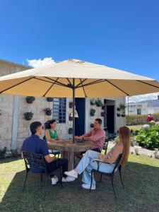 a group of people sitting around a table under an umbrella at Mambe refugio in Piedecuesta