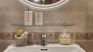 a bathroom sink with two bottles of soap and a mirror at Apartamento a un paso de la playa in Sant Feliu de Guixols +29 photos