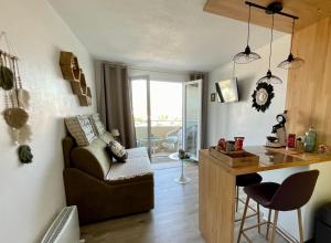 a living room with a couch and a table and a desk at Studio avec balcon à 50 m de la corniche vendéenne in Saint-Hilaire-de-Riez