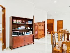 a living room with a cabinet and a microwave at Kasih HomeStay Banyuwangi Mount Ijen Crater in Banyuwangi
