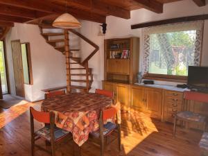 a dining room with a table and a spiral staircase at Dom Gaja in Ińsko