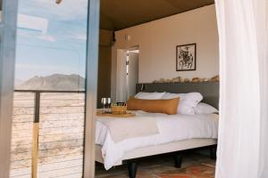 a bedroom with a bed and a balcony with a view at Camp Elena - Luxury Tents Minutes from Big Bend and Restaurants in Terlingua