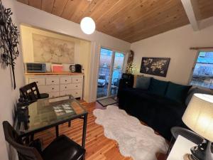 a living room with a black couch and a glass table at Arcata Forest Retreat Peaceful Redwood Suite 5 min to Downtown Arcata w Private Patio Fountain & Fire Pit in Arcata
