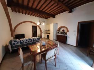 a living room with a table and a couch at Savelli House in Siena center with private parking and garden in Siena