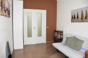 una sala de estar con puertas blancas y una silla en Domus Bracco, en Nápoles