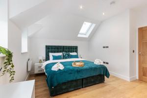 a bedroom with a bed with a blue comforter at Bright & Airy 2-Bedroom, Leatherhead, Sleeps 4 in Leatherhead