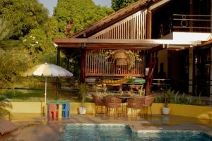 a patio with a table and chairs next to a pool at Casa das Seringueiras in Alter do Chao