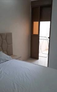 a bedroom with a bed and a door to a balcony at Appartement Sun of Saïdia in Saidia 
