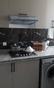 a kitchen with a stove with pots and pans on it at Appartement Sun of Saïdia in Saidia 