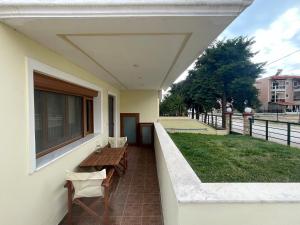 een balkon met een houten tafel en stoelen op een huis bij Joanna's House in Néa Péramos