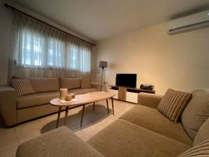 a living room with two couches and a table at Joanna's House in Nea Peramos