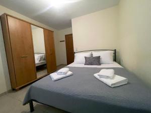 een slaapkamer met een bed met twee handdoeken erop bij Joanna's House in Néa Péramos