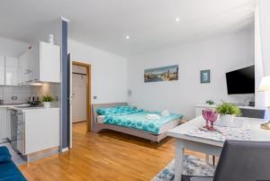 una cucina e un soggiorno con letto e tavolo di Augustina Apartment a Rovigno (Rovinj)