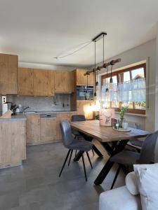 a kitchen and dining room with a wooden table and chairs at Ferienwohnung Hirsch im Allgäu in Oberreute