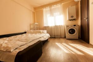 a bedroom with a bed and a washing machine at Studio 24 in Iaşi