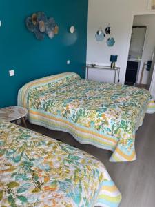 two beds in a room with blue walls at Lagalerne in Neuville-de-Poitou