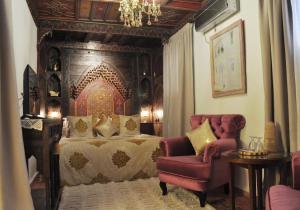 a bedroom with a bed and a chair at Riad Cherifa in Chefchaouene