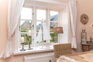 a window with a model sailboat on a window sill at Mühlenhaus "Teil 1" in Wrixum