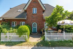 a red brick house with a white picket fence at J Jacobs in Wrixum