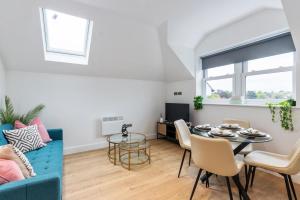 ein Wohnzimmer mit einem blauen Sofa und einem Tisch in der Unterkunft Premium 2-Bedroom Apartment, Leatherhead, Sleeps 4 in Leatherhead
