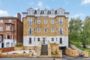 ein großes Backsteingebäude mit Treppen davor in der Unterkunft Premium 2-Bedroom Apartment, Leatherhead, Sleeps 4 in Leatherhead