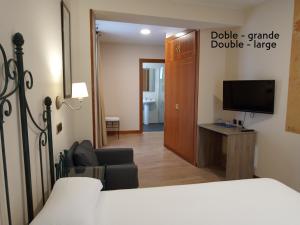 a bedroom with a bed and a desk and a tv at Pensión Begoña - centro ciudad in Bilbao