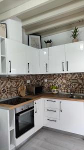a kitchen with white cabinets and a counter top at Luna Grande in Archangelos +18 photos