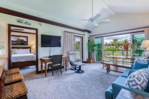 a hotel room with a bedroom with a bed and a desk at Waipouli Beach Resort E301 in Kapaa